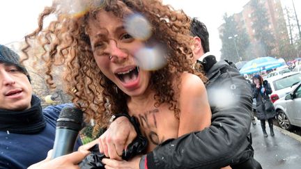 Interpellation d'une des trois f&eacute;ministes qui ont tent&eacute; de se lancer sur Silvio Berlusconi &agrave; Milan (Italie) le 24 f&eacute;vrier 2013.&nbsp; (GIUSEPPE CACACE / AFP)