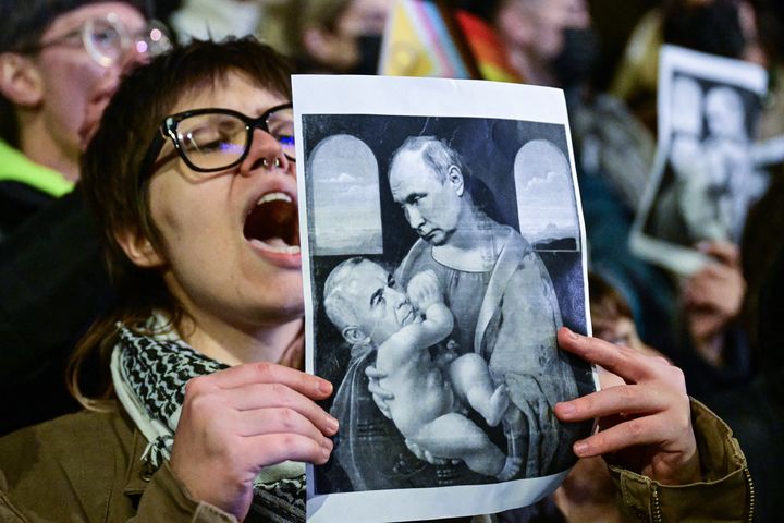 Un montage présentant Vladimir Poutine en Marie et Calin Georgescu en enfant Jésus, brandi lors d'une manifestation contre le candidat d'extrême droite à la présidentielle roumaine, à Bucarest (Roumanie), le 25 novembre 2024. (DANIEL MIHAILESCU / AFP)