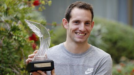 Le perchiste fran&ccedil;ais Renaud Lavillenie pose avec le troph&eacute;e d'athl&eacute;te de l'ann&eacute;e, le 21 novembre 2014 &agrave; Monaco. (VALERY HACHE / AFP)