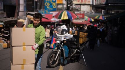 Un livreur décharge des&nbsp;cartons dans un marché du centre de Séoul le 12 mars 2015. (Illustration) (ED JONES / AFP)