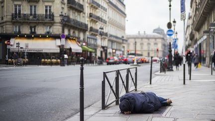 Un sans-abri dort sur le trottoir à Paris, le 16 janvier 2017. (MARTIN BUREAU / AFP)