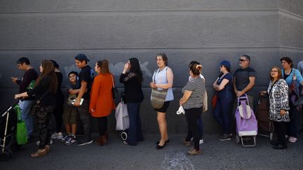 Une queue à l'entrée d'un supermarché de Santiago (Chili), le 22 octobre 2019. (PABLO VERA / AFP)