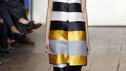 La collection Cédric Charlier est faite de féminité, de fluidité, teintée d’une sophistication nonchalante : des décolletés plongeants, des robes suspendues à de fines bretelles, des t-shirts, des bustiers, des jupes aux cascades de plis color block, des carrés fluides pour les jupes, les tops et les robes. La sophistication est apportée par les lignes tailoring brodées sur les vestes et les robes, renforcée par les nœuds et les boules géantes posées sur les claquettes. Les matières sont fluides. Les couleurs sont saturées, du rose au vrai rouge, du lagon au vert émeraude. Les bijoux sont enrichis par des pierres brutes : pyrite, améthyste, cristal de roche.
 (FRANCOIS GUILLOT / AFP)