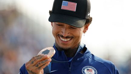 Le médaillé de bronze américain Nyjah Huston tient sa médaille après la cérémonie de victoire de l'épreuve masculine de skateboard de rue lors des JO 2024 à La Concorde (Paris), le 29 juillet 2024. (ODD ANDERSEN / AFP)