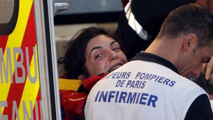 La journaliste Edith Bouvier, couch&eacute;e sur un brancard, sourit &agrave; son arriv&eacute;e en France, le 2 mars 2012 &agrave; l'a&eacute;roport de Villacoublay (Yvelines). (JACQUES DEMARTHON / AFP)