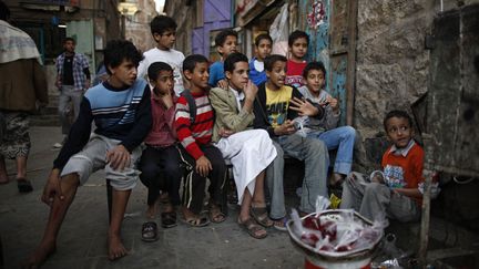 De jeunes gar&ccedil;ons regardent la t&eacute;l&eacute;vision dans une rue de Sanaa (Y&eacute;men), le 7 janvier 2013. (KHALED ABDULLAH ALI AL MAHDI / REUTERS)