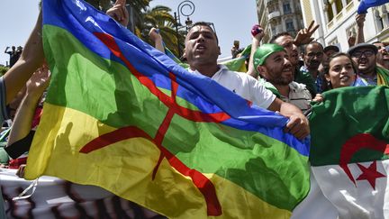 Des manifestants algériens brandissent les drapeaux national et amazigh à Alger, le 21 juin 2019. (RYAD KRAMDI / AFP)