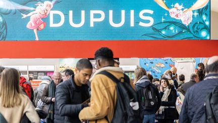 Des visiteurs devant le stand des éditions Dupuis au Festival international de la BD, à Angoulême, le 26 janvier 2023. (YOHAN BONNET / AFP)