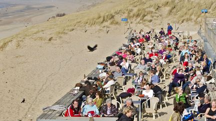 On profite du soleil sur une terrasse de la plage de Bloemendaal (Pays-Bas), le 15 mars 2012. (KOEN SUYK / EPA / MAXPPP)