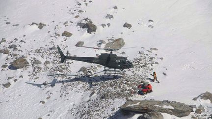 Des secouristes prennent en charge l'alpiniste Elisabeth Revol sur le Nanga Parbat, le 28 janvier 2018. (SAYED FAKHAR ABBAS / AFP)