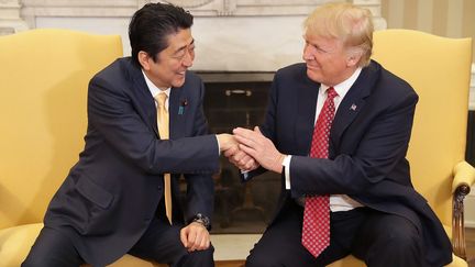 Le président américain Donald Trump (à droite) serre vigoureusement la main au Premier ministre japonais Shinzo Abe, à la Maison Blanche, le 10 février 2017. (CHIP SOMODEVILLA / DPA / AFP)