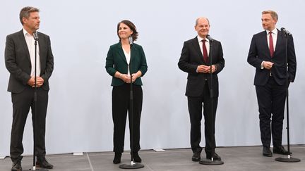 Robert Habeck et Annalena Baerbock, des Verts, le social-démocrate Olaf Scholz et le leader du parti libéral-démocrate, Christian Lindner, lors d'une déclaration sur un accord préliminaire entre les trois forces politiques pour la formation d'un gouvernement, le 15 octobre 2021 à Berlin (Allemagne).&nbsp; (CHRISTOF STACHE / AFP)