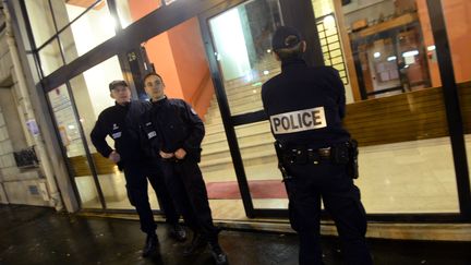 Des policiers contr&ocirc;lent l'acc&egrave;s &agrave; l'immeuble o&ugrave; deux s&oelig;urs ont &eacute;t&eacute; retrouv&eacute;es mortes, jeudi 20 f&eacute;vrier, dans le 14e arrondissement de Paris. (PIERRE ANDRIEU / AFP)