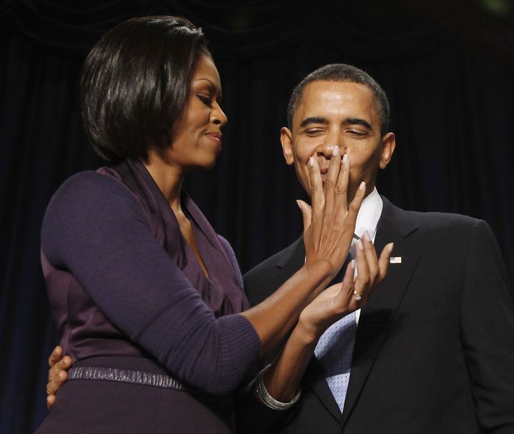 Michelle Obama efface les traces de rouge à lèvres qu'elle a laissées sur le visage du président des Etats-Unis, le 4 février 2010. (JASON REED / REUTERS)