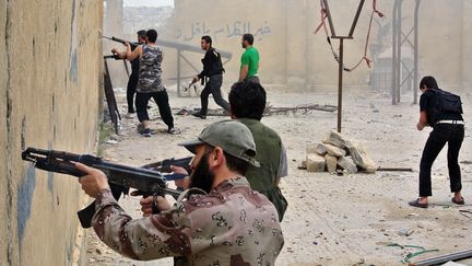 Des rebelles syriens tirent sur des soldats de l'arm&eacute;e syrienne r&eacute;guli&egrave;re, &agrave; Alep (Syrie), le 12 mai 2013. (AFP )