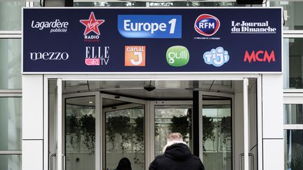 Deux personnes entrent dans le bâtiment du groupe Lagardère,&nbsp;à Paris, dans lequel se trouve la rédaction d'Europe 1. (PHILIPPE LOPEZ / AFP)