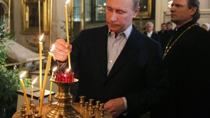 Le premier ministre russe Vladimir Poutine lors de la messe du No&euml;l orthodoxe &agrave; Saint-Petersbourg, le 7 janvier 2012. (DMITRY LOVETSKY / POOL / AFP)