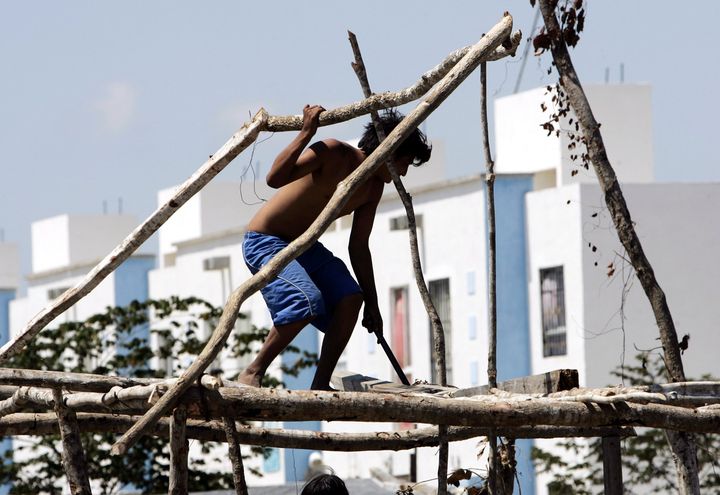 Un homme fabrique une cabane, &agrave; Cancun (Mexique), le 22 avril 2008. (VICTOR RUIZ / NOTIMEX / AFP)