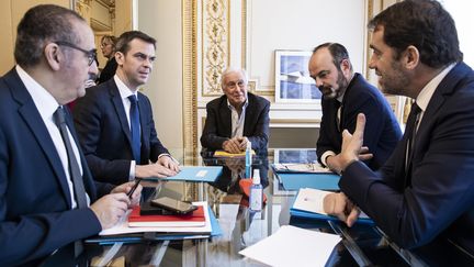 Le professeur Jean-François Delfraissy, président du Conseil scientifique (au centre), entouré de Laurent Nunez, Olivier Véran, Edouard Philippe et Christophe Castaner&nbsp;lors d'une réunion au ministère de l'Intérieur le 13 mars 2020 (ALEXIS SCIARD / MAXPPP)