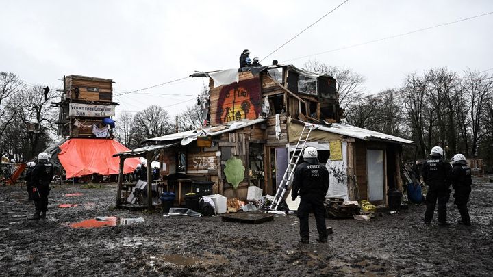 La police se tient devant la maison en bois d'activistes environnementaux installés à Lützerath (Allemagne), à l'occasion d'une vaste opération d'évacuation, le 12 janvier 2023. (INA FASSBENDER / AFP)