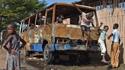 Des enfants jouent dans un v&eacute;hicule incendi&eacute;, &agrave; Bujumbura (Burundi), le 17 mai 2015. (CARL DE SOUZA / AFP)