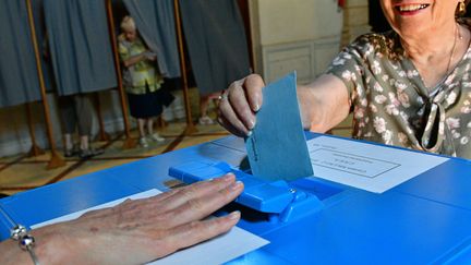 un bulletin de vote s'apprète à être déposé dans une urne pour le vote du premier tour des législatives, à Millau (Aveyron), le 11 juin 2017. (MAXPPP)