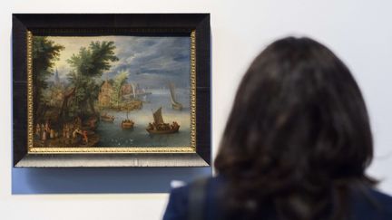 Une personne regarde le tableau "River landscape, 1630" par l'artiste flamand Pieter Brueghel le Jeune, à l'exposition de la collection Gurlitt au Kunstmuseum de Berne (Suisse), le 18 avril 2018. (ANTHONY ANEX/AP/SIPA / AP)