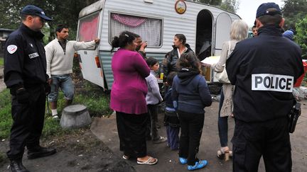 Des policiers participent au d&eacute;mant&egrave;lement d'un camp de Roms &agrave; Hellemmes et Villeneuve-d'Ascq, pr&egrave;s de&nbsp;Lille (Nord), le 9 ao&ucirc;t 2012. (PATRICK DELCROIX / LA VOIX DU NORD / MAXPPP)