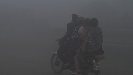 Des habitants de Lahore au milieu du smog, au Pakistan, le 14 décembre 2023. (ARIF ALI / AFP)