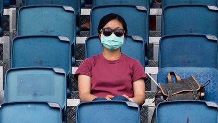 Une spectatrice regarde un entraînement pendant l'Open d'Australie, à Melbourne, le 15 janvier 2020.&nbsp; (ASANKA BRENDON RATNAYAKE / AFP)