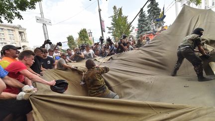 Des habitants de Kiev tentent de d&eacute;monter les camps des derniers activistes sur la place Ma&iuml;dan, samedi 9 ao&ucirc;t 2014.&nbsp; (SERGEI SUPINSKY / AFP)