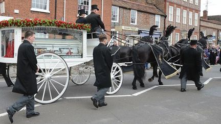 Un carrosse blanc vitré, tiré par quatre chevaux noirs a transporté le cercueil de Robin Gibb à travers les rues de Thame, petite ville du centre de l&#039;Angleterre où a vécu longtemps la star.
 (ANDREW YATES / AFP)