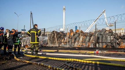 Des pompiers se tiennent devant l'usine sinistrée de Lubrizol, à Rouen (Seine-Maritime), le 27 septembre 2019. (LOU BENOIST / AFP)