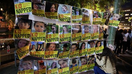 Portraits of children held hostage by Hamas are displayed in front of UNICEF premises on November 20, 2023 in Tel Aviv.  (AHMAD GHARABLI / AFP)