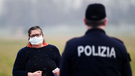 Une habitante de Casalpusterlengo au sud de Milan. la ville a été mise à l'isolement pour cause de multiplication de cas de coronavirus Covid-19. (MIGUEL MEDINA / AFP)