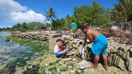 Des habitants des &icirc;les Kiribati construisent un mur de pierres pour tenter de lutter contre la mont&eacute;e du niveau de la mer. Photo rendue publique en 2013 par le secr&eacute;tariat de la communaut&eacute; du Pacifique. (SPC / AFP)