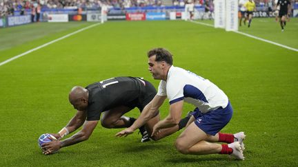 All Blacks winger Marc Tilia beat his French counterpart Damien Benaud to score his first World Cup try after two minutes (Christophe Ena/AP)