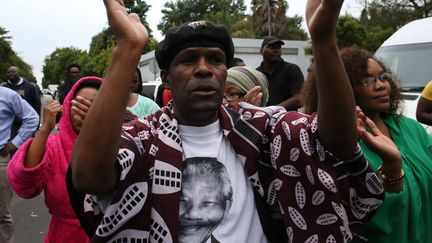 Les habitants de Soweto&nbsp;en Afrique du Sud rendent hommage &agrave; Nelson&nbsp;Mandela avec des chants et des danses, le 6 d&eacute;cembre 2013. (ALEXANDER JOE / AFP)