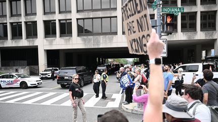 "Les présidents ne sont pas des rois", brandit sur une pancarte un manifestant à l'adresse de l'ancien président alors que sa voiture arrive au tribunal fédéral de Washington où l'attend la juge pour sa troisième inculpation. (BRENDAN SMIALOWSKI / AFP)