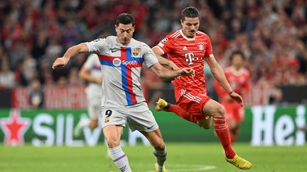 Robert Lewandowski et Marcel Sabitzer au duel lors du match entre le Bayern et Barcelone, le 13 septembre 2022. (CHRISTOF STACHE / AFP)