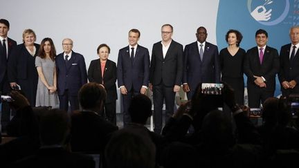 Photo de famille lors du premier Forum de Paris sur la Paix, à La Villette, le 11 novembre 2018. A droite du président français Emmanuel Macron, Christophe Deloire, président de Reporters sans Frontières et le président sénégalais Macky Sall. A sa gauche, les lauréates du prix Nobel de la paix 2003 et 2018 Shirin Ebadi et Nadia Murad. Entre elles deux, le président tunisien Beji Caid Essebsi. (Yoan VALAT / POOL / AFP)