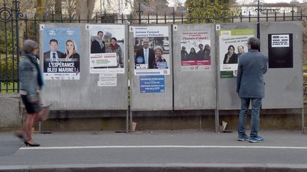 Des passants devant les panneaux &eacute;lectoraux &agrave; Rennes (Ille-et-Vilaine), le 17 mars 2015. (DAMIEN MEYER / AFP)