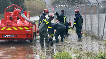 Des pompiers pompent l'eau à l'aéroport d'Ajaccio.&nbsp; (JEAN-PIERRE BELZIT / MAXPPP)