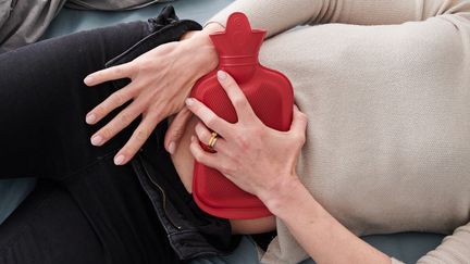 Une bouillote appliquée sur le ventre d'une femme à cause de règles douloureuses. (ANNETTE RIEDL / DPA via MAXPPP)