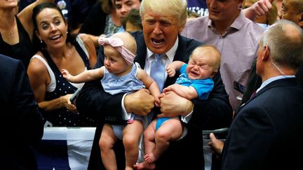 Le feeling avec les bébés, ça n'est pas donné à tout le monde ! Il reste 101 jours à l'homme d'affaires de 70 ans pour se faire aimer des Américains. Grands ... et petits. (Carlo ALLEGRI / REUTERS)