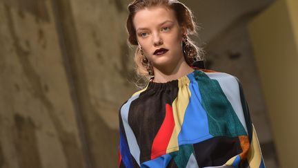 Noeuds et rubans virevoltants chez Marni, où Consuelo Castiglioni propose des princesses contemporaines. Ici, les volumineuses manches bouffantes sculptent le bas du bras et sont toutes amovibles, retenues par de gros boutons ronds et plats ou par des rubans. La collection est graphique et épurée avec des capes et tuniques allongées derrière et raccourcies sur le devant dans un arrondi dévoilant le ventre. Même procédé pour jupes et robes laissant voir les jambes par une fente ovale. Mais des détails un brin baroque viennent casser ce rythme linéaire, tels ces motifs Arlequin, les disques en plastique translucide colorés qui décorent le haut d'un ensemble en coton blanc ou encore ces imprimés et taches vernies ou en velours dévoré rappelant le papier marbré vénitien.
 (TIZIANA FABI / AFP)