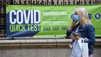 Une Britannique passe devant un centre de test, le 16 juin 2021 à Blackburn (Royaume-Uni). (OLI SCARFF / AFP)