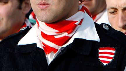 Foulard et écusson rappellent le "drapeau d’Arpad", symbole d’une Hongrie triomphante du IXe au XIVe.

Mais la polémique sur ce choix vient du fait que ce drapeau a refait surface en 1944 comme symbole officiel du régime des Croix fléchées, parti politique hongrois pro-nazi. (REUTERS/Laszlo Balogh)