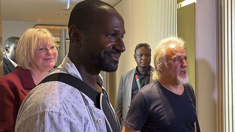 French journalist Olivier Dubois (foreground) and American Jeffery Woodke (right), both released, upon their arrival at Niamey airport in Niger, March 20, 2023. (SOULEYMANE AG ANARA / AFP)