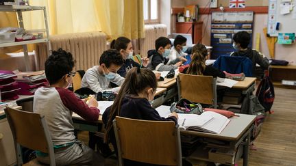 Des élèves d'élémentaire portent le masque en classe, le 26 avril 2021, dans une école de Bron, dans la métropole de Lyon. (SABINE GREPPO / HANS LUCAS / AFP)